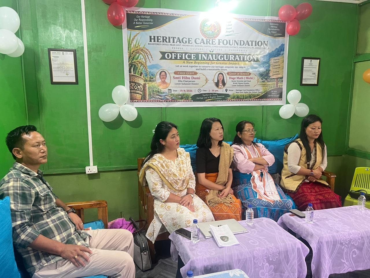 Guests seated beneath the office inauguration banner