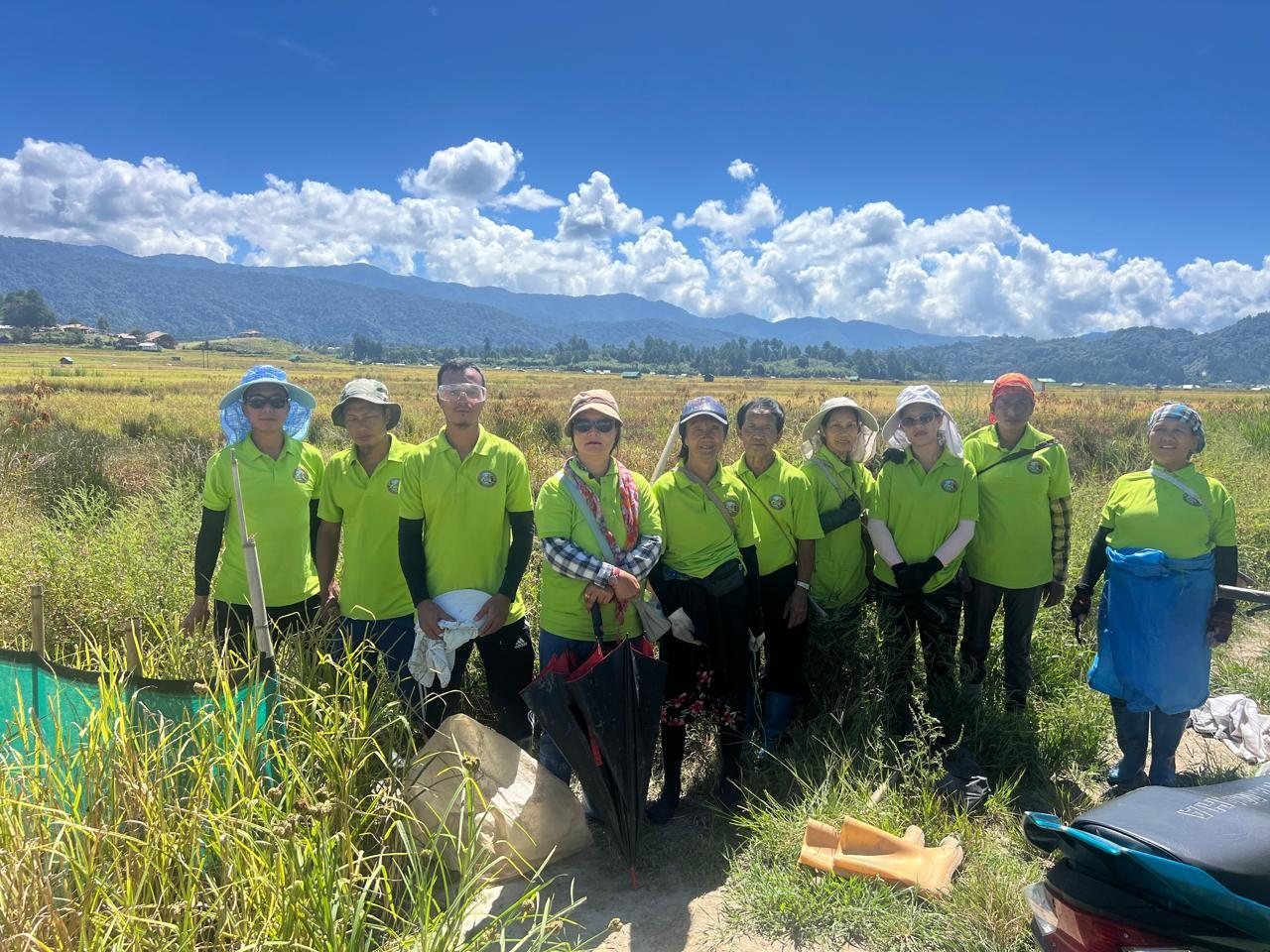 Foundation volunteers in matching shirts standing in a field under a blue sky